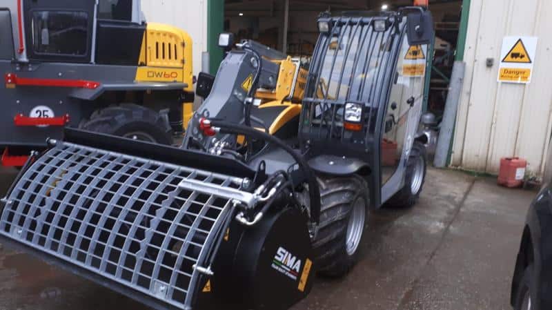 Industrial loader machine outside warehouse entrance.