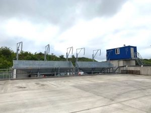 Industrial site with metal structures and blue cabin.