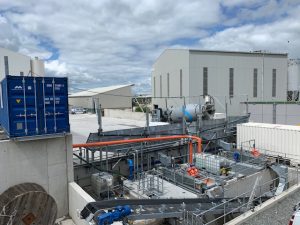 Industrial facility with containers and equipment outside.