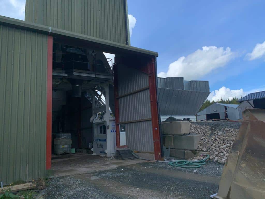 Industrial building with open entrance and machinery inside.