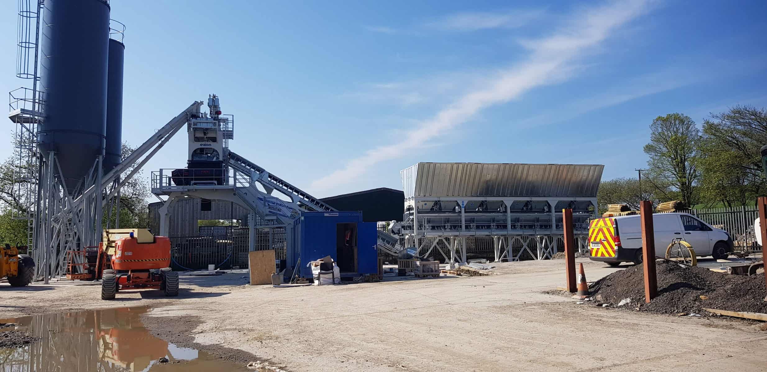 Concrete batching plant with machinery on construction site.