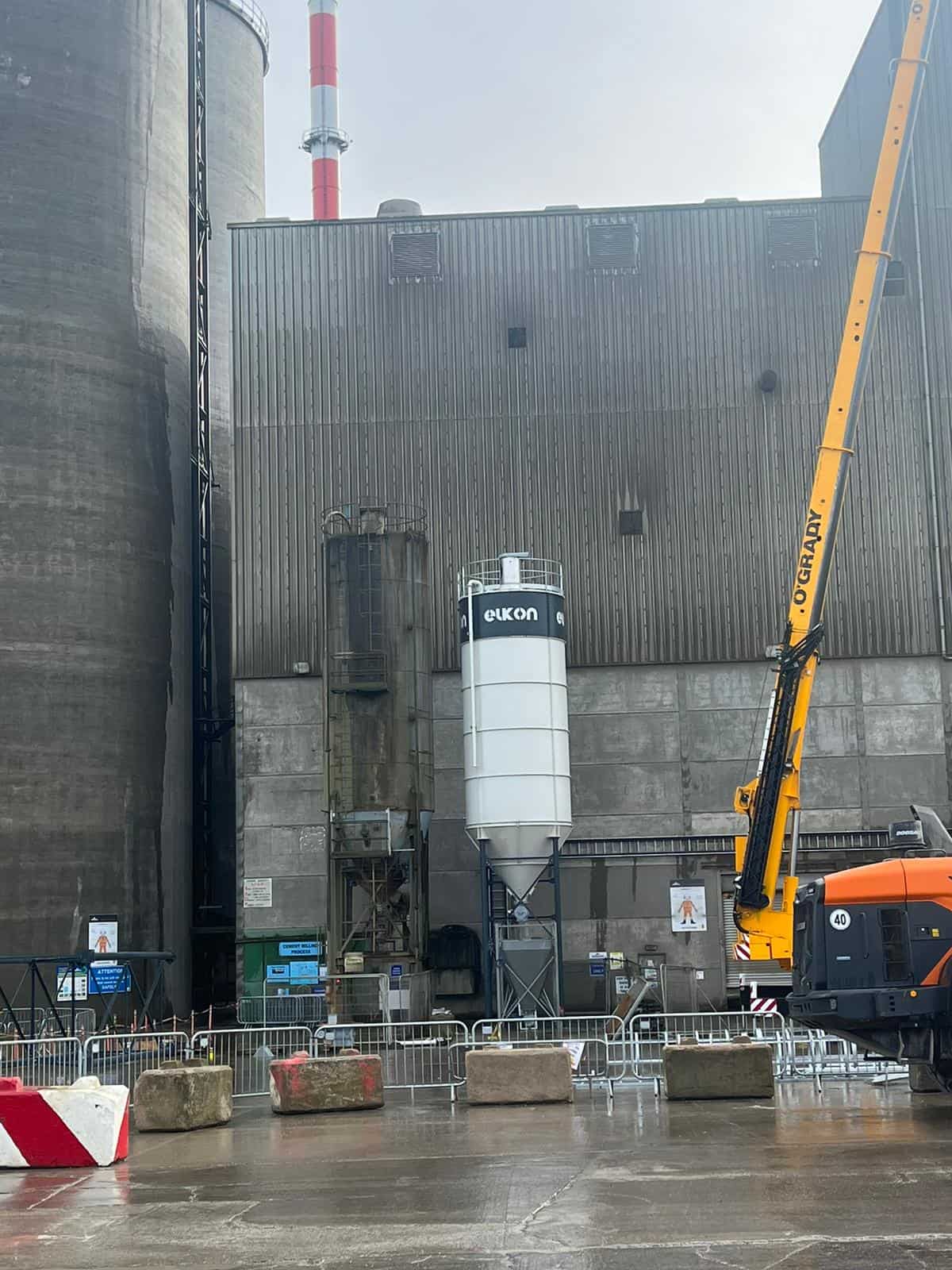 Industrial site with construction equipment and silo.