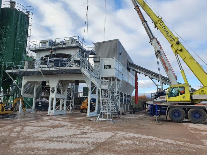 Construction site with cranes and industrial machinery.