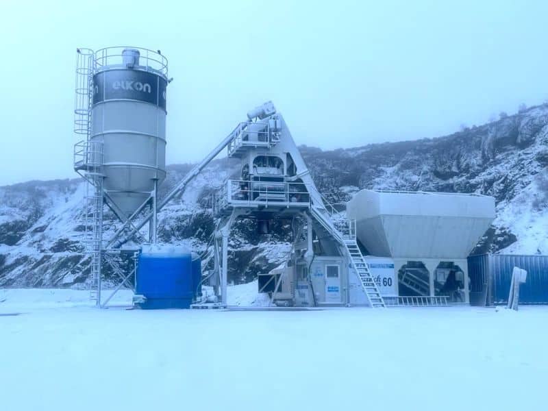 Snowy concrete plant in winter landscape.