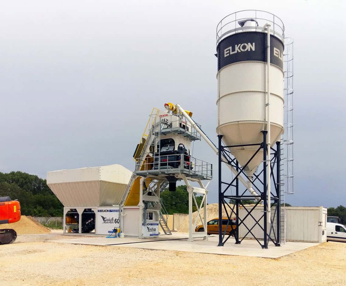 Concrete batching plant with large silo outdoors.