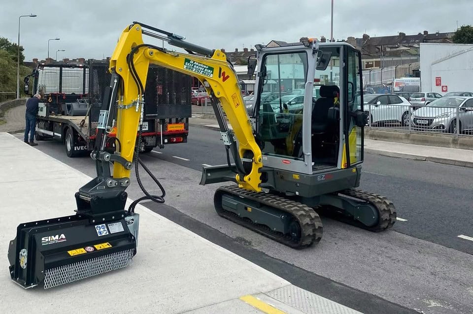 Small digger with attachment on urban street